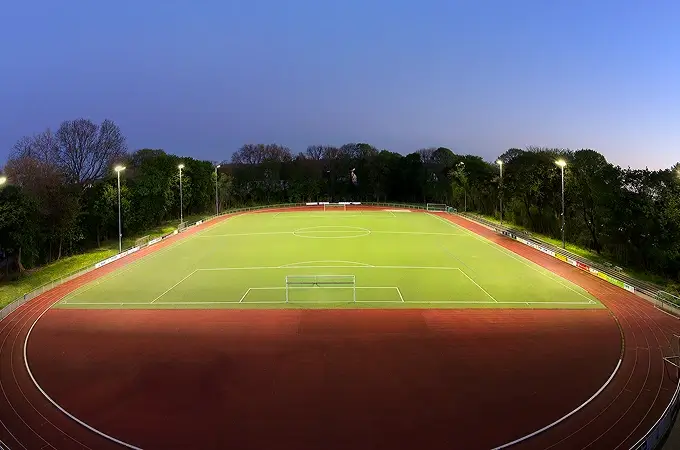 beleuchteter Sportplatz in der Abenddämmerung