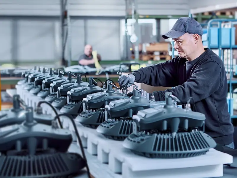 Mitarbeiter montiert moderne LED-Industrieleuchten in der Fertigung bei Schmidt-Strahl